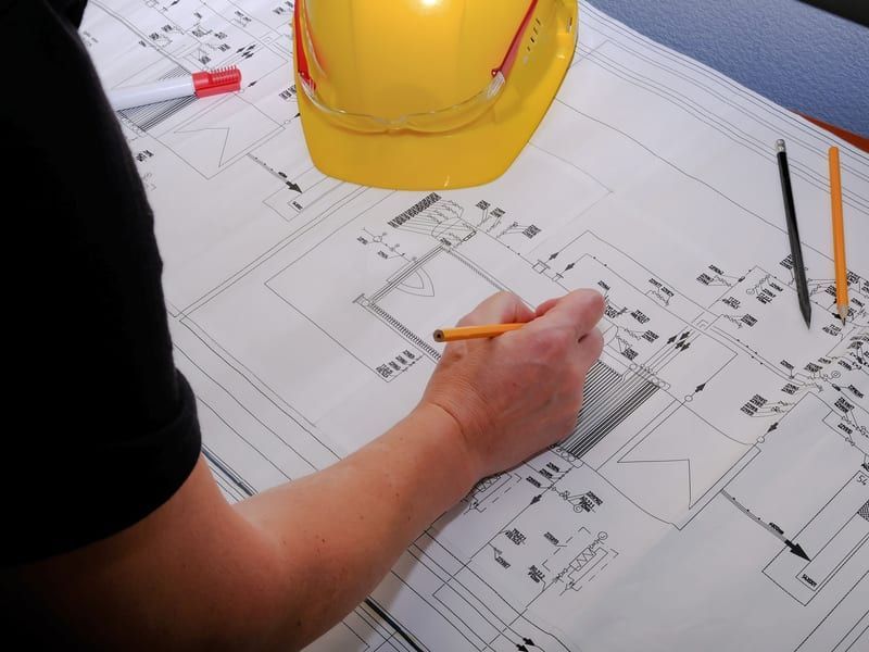 Ingeniera eléctrica trabajando sobre el esquema de una instalación de media tensión